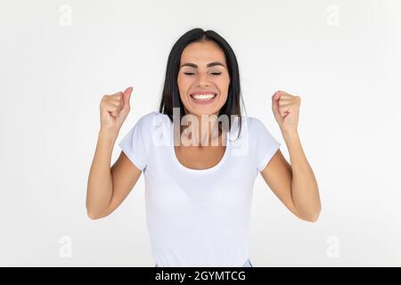 Porträt einer Frau, die eine Gewinnergeste auf weißem Hintergrund macht Stockfoto