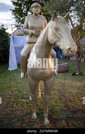 Etsdorf, Deutschland. Okt. 2021. Eine Reiterstatue der noch-Bundeskanzlerin Angela Merkel nach der Enthüllung. Die 2.70 Meter hohe lebensgroße Skulptur wurde aus Leichtbeton und mit einem entsprechenden 3D-Drucker gefertigt. Die Idee kam vom Künstler Wilhelm Koch, der seit Jahrzehnten ungewöhnliche Projekte realisiert, wie ein Luftmuseum mit Skulpturen aus aufgeblasenen Gummischläuchen. Quelle: Daniel Karmann/dpa/Alamy Live News Stockfoto