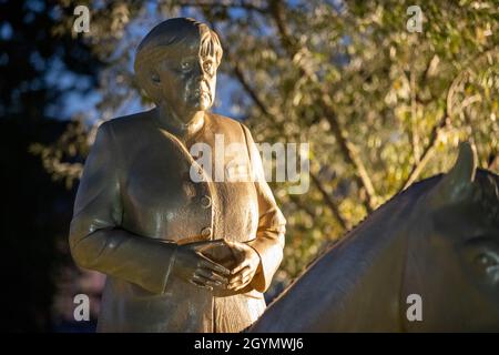 Etsdorf, Deutschland. Okt. 2021. Eine Reiterstatue der noch-Bundeskanzlerin Angela Merkel nach der Enthüllung. Die 2.70 Meter hohe lebensgroße Skulptur wurde aus Leichtbeton und mit einem entsprechenden 3D-Drucker gefertigt. Die Idee kam vom Künstler Wilhelm Koch, der seit Jahrzehnten ungewöhnliche Projekte realisiert, wie ein Luftmuseum mit Skulpturen aus aufgeblasenen Gummischläuchen. Quelle: Daniel Karmann/dpa/Alamy Live News Stockfoto