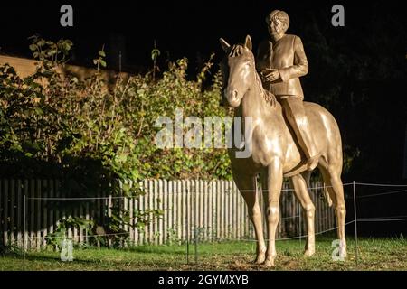 Etsdorf, Deutschland. Okt. 2021. Eine Reiterstatue der noch-Bundeskanzlerin Angela Merkel nach der Enthüllung. Die 2.70 Meter hohe lebensgroße Skulptur wurde aus Leichtbeton und mit einem entsprechenden 3D-Drucker gefertigt. Die Idee kam vom Künstler Wilhelm Koch, der seit Jahrzehnten ungewöhnliche Projekte realisiert, wie ein Luftmuseum mit Skulpturen aus aufgeblasenen Gummischläuchen. Quelle: Daniel Karmann/dpa/Alamy Live News Stockfoto