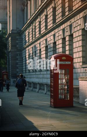 Vertikale Aufnahme von roten Telefonzellen auf den Bürgersteigen der Stadt Stockfoto