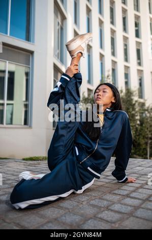 Attraktive asiatische Frau in Sportbekleidung in einer Gymnastik-Pose Stockfoto