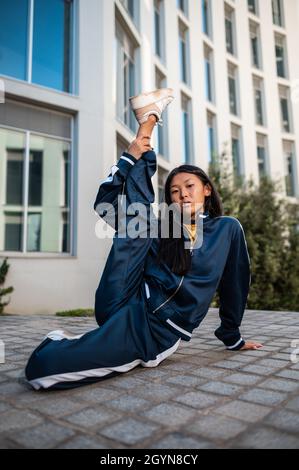 Attraktive asiatische Frau in Sportbekleidung in einer Gymnastik-Pose Stockfoto