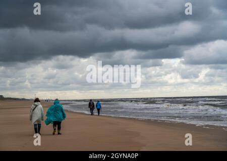 Spaziergänger am Strand, dunkle Sturmwolken, raues Meer, Herbst an der Nordsee in Nordholland, zwischen den Städten Egmond aan Zee und Bergen aan Zee, Stockfoto