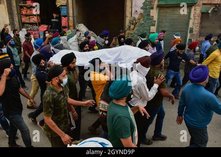 Kaschmir, Indien. Okt. 2021. (ANMERKUNG DER REDAKTION: Bild zeigt den Tod)Sikh-Trauernde tragen die Leiche des getöteten Supinder Kour, eines Schulleitern, der während der Trauerprozession in Srinagar von unbekannten Schützen getötet wurde. Der Direktor und ein Lehrer einer Regierungsschule wurden von unbekannten Schützen getötet, die in Srinagar als militante Kämpfer verdächtigt wurden, das jüngste in einer Serie von gezielten Tötungen im Kaschmir-Tal. Der Angriff erfolgt weniger als 48 Stunden, nachdem am Dienstag drei Personen bei Streiks getötet wurden. Die Opfer stammten aus Sikh und Hindu-Gemeinden. Der Lehrer, Deepak Chand, war ein Hindu aus Jammu und den Stockfoto