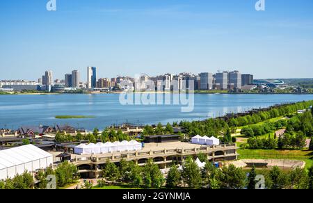 Panorama von Kasan im Sommer, Tatarstan, Russland. Blick vom Kreml auf den grünen Park, den Damm und die modernen Gebäude am Fluss im Stadtzentrum von Kazan. Stockfoto