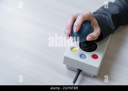 Frau mit zerebraler Lähmung arbeitet an einer spezialisierten Computermaus. Stockfoto