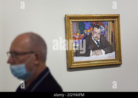 Besucher mit Gesichtsmaske vor dem Tempera-Gemälde „Portrait of Ivan Abramovich Morozov“ des russischen impressionistischen Malers Valentin Serov (1909), das in der Ausstellung „Ikonen der modernen Kunst aus der Sammlung Morozov“ in der Fondation Louis Vuitton in Paris, Frankreich, zu sehen ist. Ivan Abramowitsch Morozov war ein russischer Kunstsammler, der eine der besten Sammlungen der französischen modernistischen Kunst der Welt besaß. Im Hintergrund des Porträts ist das Gemälde 'Fruits and Bronze' des französischen Malers Henri Matisse (1910) aus seiner Sammlung dargestellt. Die Ausstellung zur Sammlung Morozov läuft bis Stockfoto