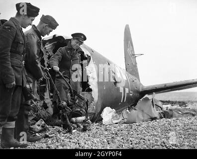 Soldaten betrachten die Maschinengewehre eines abgeschossenen Heinkel He-111-Bombers Stockfoto