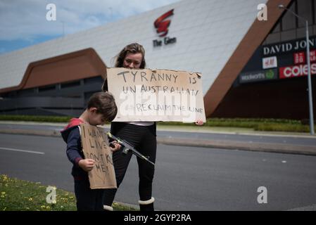 Melbourne, Australien, 9. Oktober 2021. Eine Mutter und ihr Kind halten bei einer Anti-Lockdown-Kundgebung am Straßenrand Schilder hoch, das Kind hält auch eine Spielzeugwaffe. Quelle: Jay Kogler/Alamy Live News Stockfoto