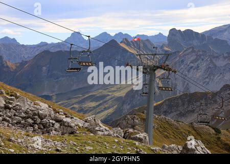 Leerer Sessellift in den alpen im Sommer mit Bergpanorama im Hintergrund Stockfoto