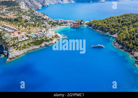 ASSOS malerisches Fischerdorf von oben, Kefalonia, Griechenland. Serielle Drohnenansicht. Segelboote liegen in türkisfarbener Bucht Stockfoto