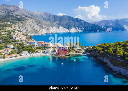 ASSOS malerisches Fischerdorf von oben, Kefalonia, Griechenland. Serielle Drohnenansicht. Segelboote liegen in türkisfarbener Bucht Stockfoto