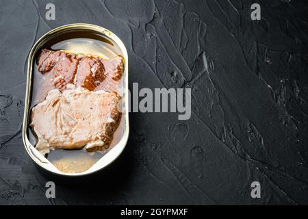 Set aus geräuchertem Fisch aus der Dose mit wildem Alaska-Lachs, auf schwarzem Hintergrund, mit Textraum und Platz für Text Stockfoto