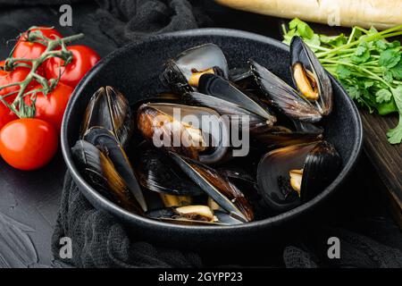 Klassische traditionelle gedünstete Muscheln in einem Weißwein in Schale, in Schale, auf schwarzem Hintergrund Stockfoto