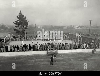 Sport in Argentinien in den 1950er Jahren – hier findet Anfang der 1950er Jahre im Estadio Eva Perón, Junín, Provinz Buenos Aires, Argentinien, eine Partie Outdoor-Basketball statt. Estadio Eva Perón ist ein Sportkomplex in Junín. Als es gegründet wurde, war es die Heimat vieler verschiedener sportlicher Aktivitäten. Heute ist es vor allem bekannt als die Heimat der Fußballmannschaft Sarmiento de Junín. Dieses Foto stammt aus einem Druck aus einem Sammelalbum/Fotoalbum, das in den 1940er/50er Jahren zusammengestellt wurde – einem Vintage-Foto aus den 1950er Jahren. Stockfoto