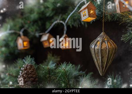 weihnachtsbaum Girlande in Form von kleinen skandinavischen Häusern bequem auf einem Ast. Stockfoto