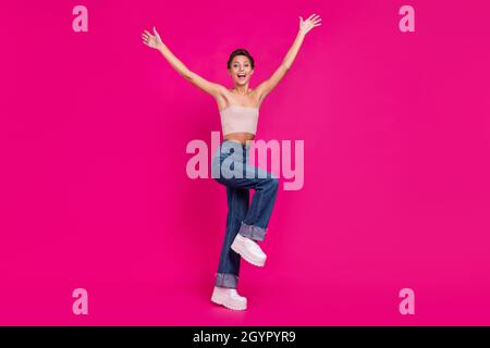 In voller Länge Foto von glücklich erstaunt fröhlich Frau heben Hände Wochenende cool isoliert auf magenta Farbe Hintergrund Stockfoto