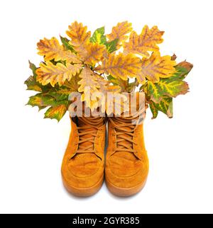 Bouquet von lebendigen Herbstblättern in orangefarbenen Sneakers isoliert auf Weiß. Herbstfarben in Mode. Stockfoto