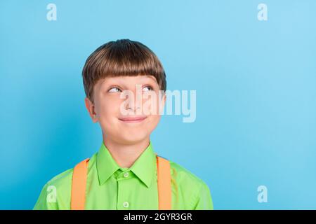 Portrait von attraktiven fröhlich neugierig Schuljunge Nerd Denken kopieren Raum isoliert über blaugrün türkisfarbenen Hintergrund Stockfoto