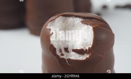Weiße Schokolade Krembo auf dem Tisch. Ein schokoladenbeschichtetes Marschmallchen, das in Israel beliebt ist. Stockfoto