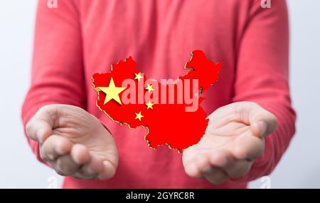 3D-Darstellung der Flagge der Volksrepublik China in einer Karte, die auf menschlichen Händen schwebt Stockfoto
