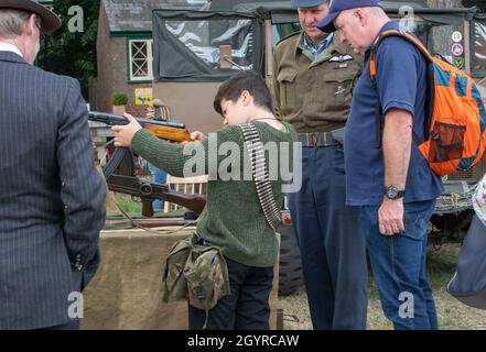Sheringham, Norfolk, Großbritannien - 14 2019. SEPTEMBER: Junge mit Bandolier hält am Wochenende der 40er Jahre einen sowjetischen PPSh-41 Maschinenpistolenhandschuh Stockfoto