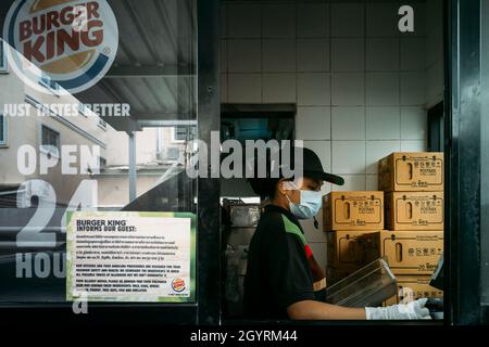 Bangkok, Thailand - 12. Oktober 2021 : Burger King Fastfood Kassierer trägt Gesichtsmaske, um Coronavirus Pandemie oder covid Ausbruch zu schützen und arbeiten Stockfoto