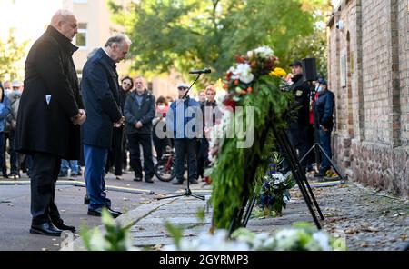 Halle, Deutschland. Oktober 2021. 09. Oktober 2021, Sachsen-Anhalt, Halle (Saale): Edgar Franke (SPD, v.l.), Beauftragte der Bundesregierung für die Sorge um Opfer und Überlebende von Terrorverbrechen in Deutschland, und Reiner Haseloff (CDU), Ministerpräsident von Sachsen-Anhalt, beugen sich zum Gedenken an die Opfer des Anschlags in Halle mit dem Kopf an den Kränzen in der Synagoge in Halle/Saale. Zwei Jahre nach dem rechtsgerichteten Terroranschlag auf den höchsten jüdischen Feiertag Jom Kippur in Halle werden die Opfer in Erinnerung gerufen. Am 09. Oktober 2019 hatte ein schwer bewaffneter Rechtsextremist versucht, die syna zu stürmen Stockfoto