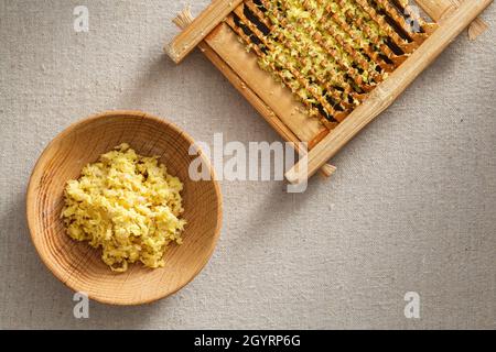 Frisches Ingwergranulat in Waschbrett und Holzplatte, frischer Ingwer auf der Wäsche Stockfoto