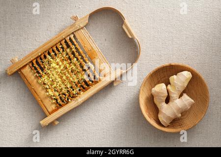 Frisches Ingwergranulat in Waschbrett und Holzplatte, frischer Ingwer auf der Wäsche Stockfoto