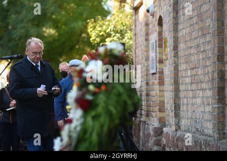 Halle, Deutschland. Oktober 2021. 09. Oktober 2021, Sachsen-Anhalt, Halle (Saale): Der Ministerpräsident von Sachsen-Anhalt, Reiner Haseloff (CDU), geht zu seiner Rede zum Gedenken an die Opfer des Anschlags in Halle an die Tür der Synagoge in Halle/Saale. Zwei Jahre nach dem rechtsgerichteten Terroranschlag auf den höchsten jüdischen Feiertag Jom Kippur in Halle werden die Opfer in Erinnerung gerufen. Am 09. Oktober 2019 hatte ein schwer bewaffneter Rechtsextremist versucht, die Synagoge zu stürmen und unter 52 Besuchern ein Massaker zu verursachen. Als er scheiterte, schoss er einen Passanten vor dem Ort der Anbetung und einen jungen Mann in einem nahe gelegenen Stockfoto