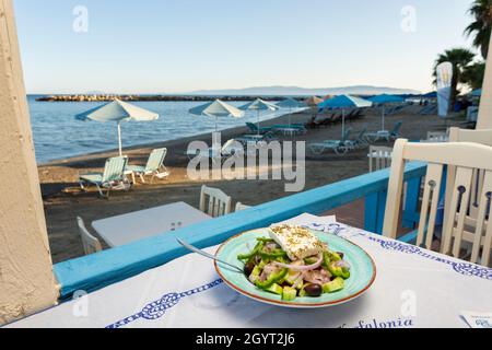Ein griechischer Salat auf dem Tisch einer Taverne am Wasser in Katelios, Kefalonia, Ioanischen Inseln, Griechenland Stockfoto