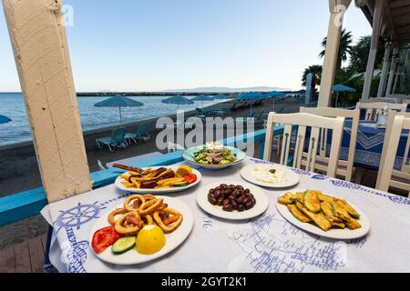 Eine Auswahl an traditionellen griechischen Gerichten auf dem Tisch einer Taverne am Wasser in Katelios, Kefalonia, Ionische Inseln, Griechenland Stockfoto