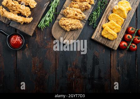 Hausgemachte knusprig gebratene Hühnerteile auf alten dunklen Holztisch, Draufsicht, mit Kopieplatz. Stockfoto