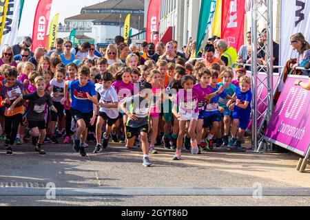 Bournemouth, Dorset, Großbritannien. Oktober 2021. Der erste Tag des Run Bournemouth, der Läufe mit fantastischem Blick auf die Küste bietet, beginnt mit Hunderten von Teilnehmern jeden Alters, die an den Rennen verschiedener Distanzen über die zwei Tage teilnehmen. Kinder im Alter von 6-8 Jahren nehmen an einem warmen, sonnigen Tag im Junior 1.5k am Meer Teil. Quelle: Carolyn Jenkins/Alamy Live News Stockfoto