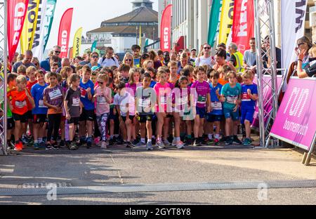 Bournemouth, Dorset, Großbritannien. Oktober 2021. Der erste Tag des Run Bournemouth, der Läufe mit fantastischem Blick auf die Küste bietet, beginnt mit Hunderten von Teilnehmern jeden Alters, die an den Rennen verschiedener Distanzen über die zwei Tage teilnehmen. Kinder im Alter von 6-8 Jahren nehmen an einem warmen, sonnigen Tag im Junior 1.5k am Meer Teil. Quelle: Carolyn Jenkins/Alamy Live News Stockfoto