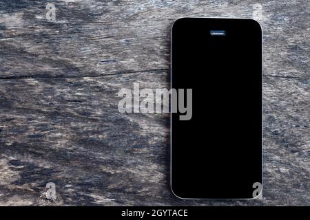 Draufsicht auf Mockup schwarzen Bildschirm Handy-Smartphone auf leeren alten Holztisch Hintergrund. Overhead View Phone Flat Lay- und Kopierplatz für Business Conce Stockfoto