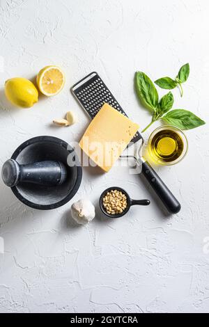 Italienische Lebensmittel, die Zutaten auf weißem Stein mit Parmesan-Käse, Basilikumblättern, Pinienkernen, Olivenöl, Knoblauch, Layout für Salz und Pfeffer. T Stockfoto