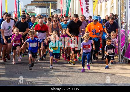 Bournemouth, Dorset, Großbritannien. Oktober 2021. Der erste Tag des Run Bournemouth, der Läufe mit fantastischem Blick auf die Küste bietet, beginnt mit Hunderten von Teilnehmern jeden Alters, die an den Rennen verschiedener Distanzen über die zwei Tage teilnehmen. Kinder im Alter von 3-6 Jahren nehmen an einem warmen, sonnigen Tag am Kinderkilometer entlang der Strandpromenade Teil. Quelle: Carolyn Jenkins/Alamy Live News Stockfoto