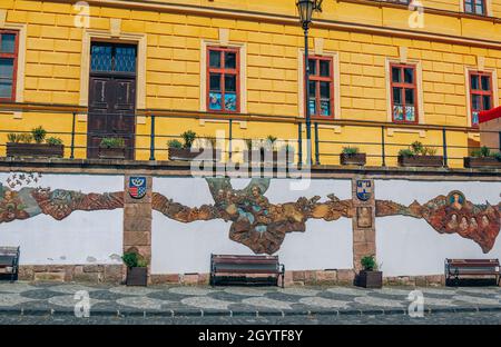 Banska Stiavnica, Slowakei – 14. August 2021: Ansicht des mittelalterlichen Gebäudes façade mit Bassrelief, das die Stadtgeschichte darstellt. Stadtbild mit Hi Stockfoto