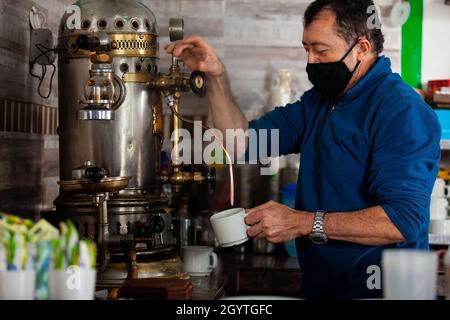 SALENTO, KOLUMBIEN - JULI 2021. Einer der Besitzer des berühmten Cafe de la Esquina, in der kleinen Stadt Salento in Kolumbien, bereitet eine Tasse Kaffee zu Stockfoto