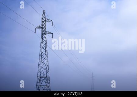 Detail von Hochspannungsmasten an einem nebligen Tag Stockfoto