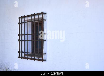 Detail eines Fensters mit einem geschmiedeten Gitter in einem kastilischen Haus. Stockfoto