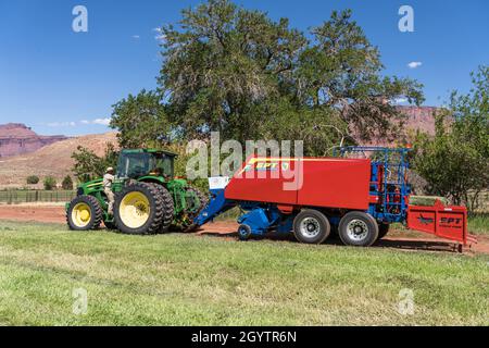 Heuballenpressen mit einem John Deere Traktor 7930 und einer GPT Twin Pak Ballenpresse auf einer Ranch im Süden von Utah. Stockfoto