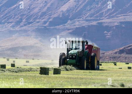 Heuballenpressen mit einem John Deere Traktor 7930 und einer GPT Twin Pak Ballenpresse auf einer Ranch im Süden von Utah. Stockfoto