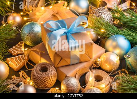 Weihnachtskomposition mit Geschenkschachteln, Weihnachtsdekorationen im Licht von Girlanden. Seitenansicht, Nahaufnahme. Stockfoto