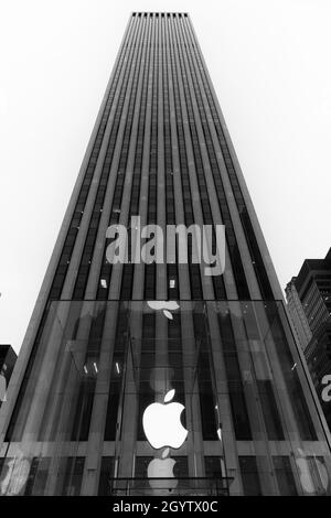 NEW YORK CITY, VEREINIGTE STAATEN - 26. Jun 2015: Eine vertikale Graustufenaufnahme eines Apfelladens vor einem Wolkenkratzer in New York City Stockfoto