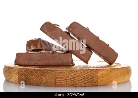 Mehrere süße Schokoladentafeln auf einem runden Holztablett, Nahaufnahme, isoliert auf Weiß. Stockfoto