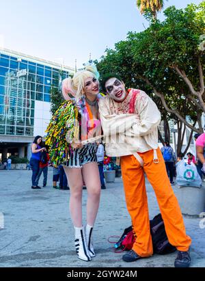 Teilnehmer Cosplayer porträtiert Harley Quinn in farbenfrohem Kostüm und Zombie Cosplayer auf der Comic Con in Los Angeles, CA, USA Stockfoto